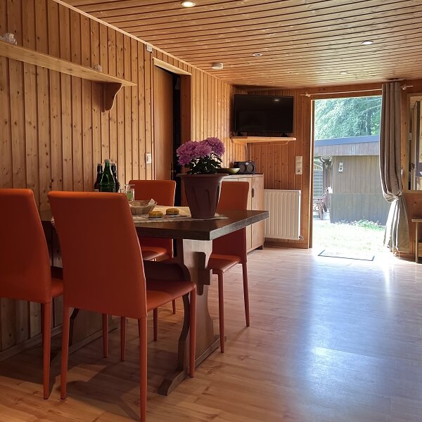Holzbungalow von Innen mit Esstisch und Blick nach Draußen