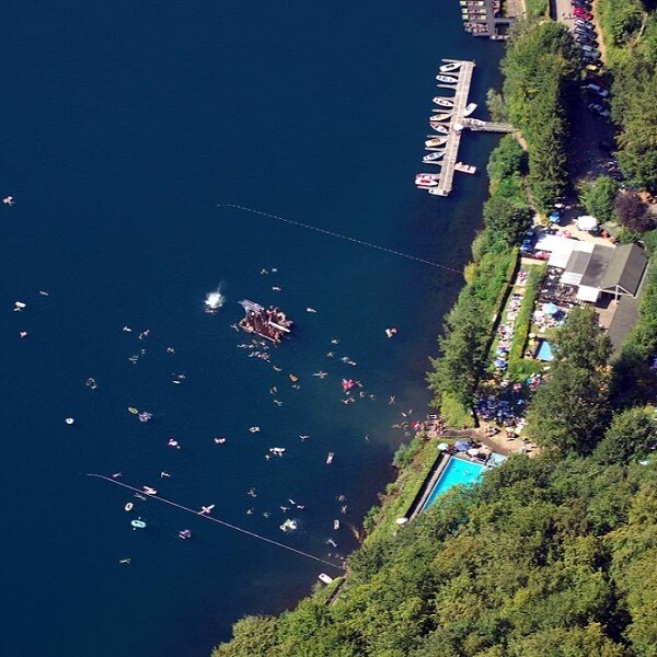 Luftbild des Schwimmbads mit Liegewiese, Badeinsel und Bootsverleih